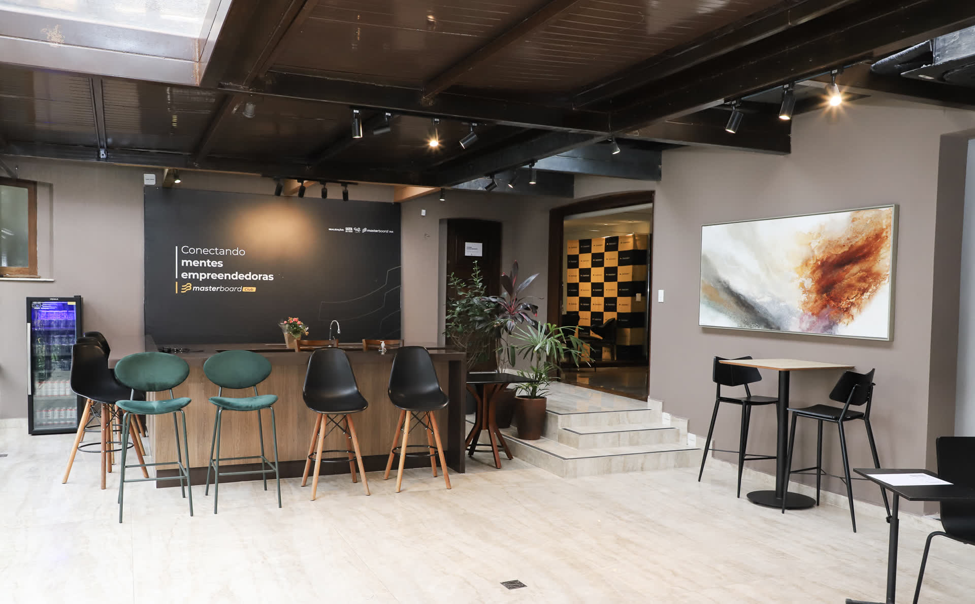 Ilha com bar de apoio — ponto de encontro para recepção e networking.